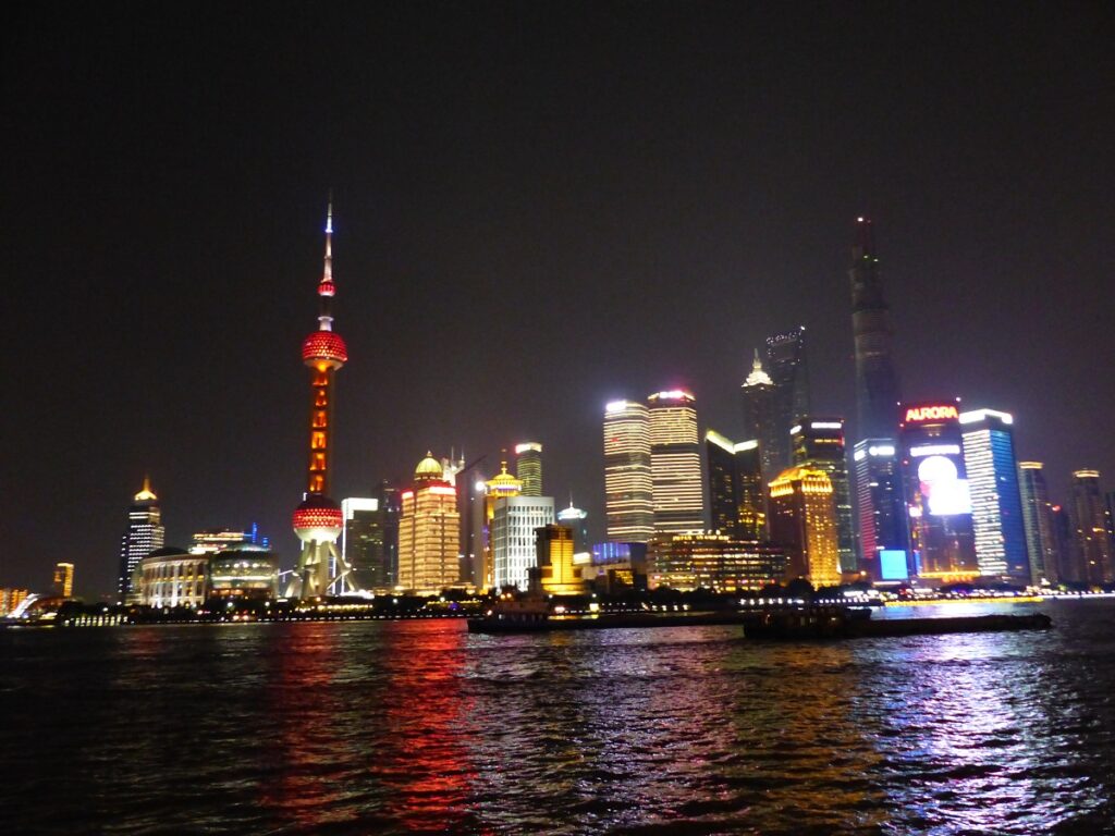 Blick auf die Skyline Shanghais bei Nacht vom Wasser aus