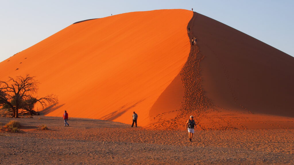 vereinzelte Menschen auf einem Berg aus Wüstensand
