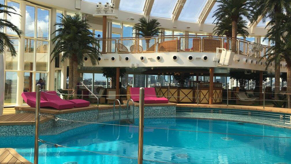 Innenbadebereich mit Palmen und mehreren Liegemöglichkeiten