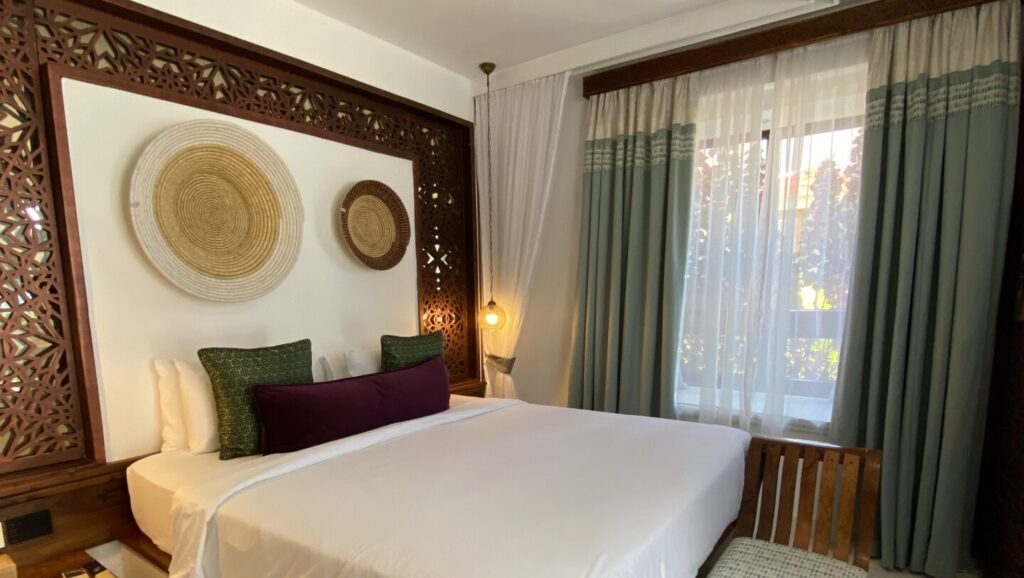 Hotelzimmer mit Doppelbett, sehr ästhetisch eingerichtet mit Holzakzenten