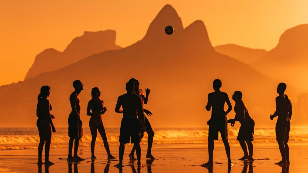 Gruppe von Menschen am Strand bei Sonnenuntergang, haben Spaß und spielen Fußball