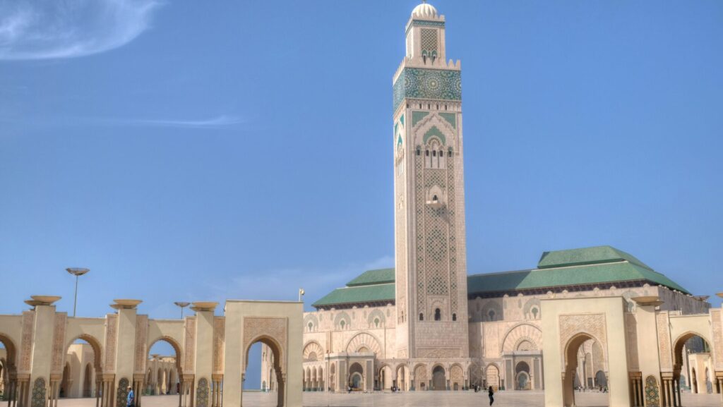 weiße Moschee mit türkisen Details und einem großen Turm, den man schon von weitem sieht