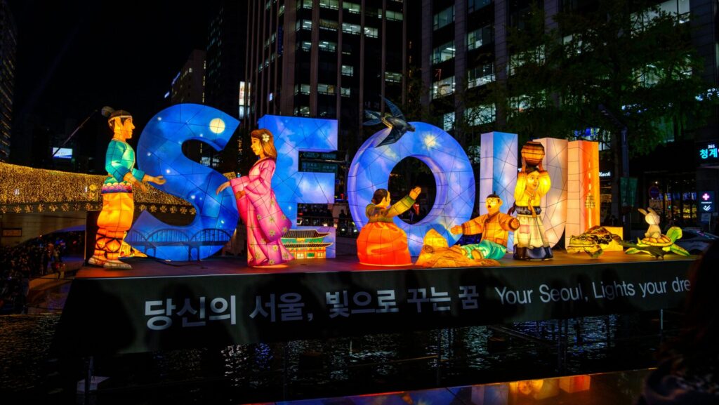 buntes beleuchtetes Seoul-Schild mit Figuren davor